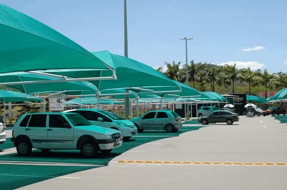 Fileira de sombreadores verdes sobre vagas de estacionamento