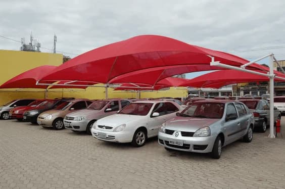 Sombreadores vermelhos cobrindo carros estacionados